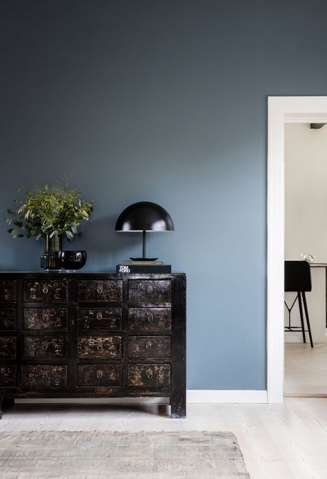 Colour is briefly introduced in the living room, which has a slate-blue feature wall and murky green painting by artist Anette Wier. Copenhagen Interior, Blue Feature Wall, Blue Walls Living Room, Serene Home, Feature Wall Living Room, Living Room Wall Color, Room Wall Colors, Painted Walls, Neutral Living Room