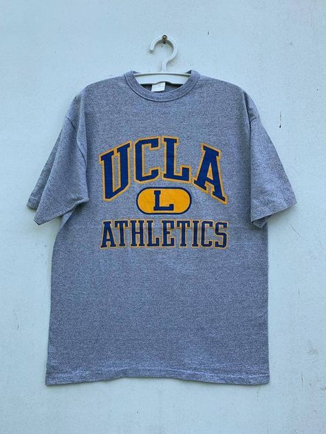 Check out this item in my Etsy shop https://www.etsy.com/listing/1260840360/vintage-80s-ucla-athletics-university-of University Tees Design, College Graphic Tee, University Shirt Design, College Tshirt Designs, Ucla Shirt, Vintage Hoodies Aesthetic, Vintage College Shirts, University Merch, California Graphic