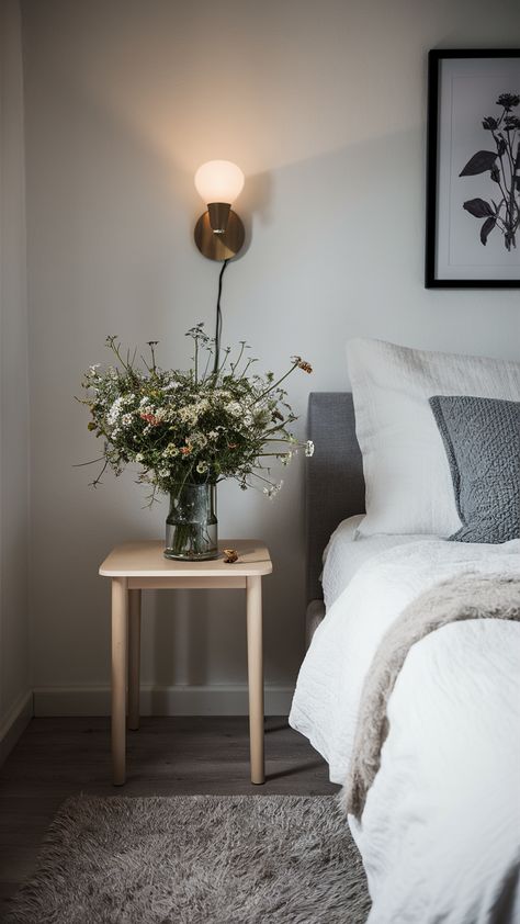 Elevate your bedroom decor with a touch of nature! This serene setup features a delicate arrangement of wildflowers atop a sleek MALM bedside table, perfectly complemented by crisp white HEMNES bed linens and a plush KNARREVIK rug. A framed botanical print adds personality, while the warm glow from a NYMÅNE wall lamp creates a tranquil atmosphere. Discover how to bring refreshing elegance into your space! Click for more styling tips and inspiration! #BedroomDecor #IKEAStyle #WildflowerArrangement #HomeInspiration #InteriorDesign #BotanicalPrints #CozyVibes Malm Bedside Table, Hemnes Bed, Wild Flower Arrangements, Ikea Style, Bedside Rug, Framed Botanicals, Bed Linens, Botanical Print, Styling Tips