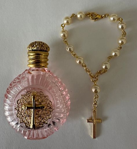 This Holy Water Bottle and Decade Rosary beads bracelet are hand made by Bohemian craftsman . The pink glass bottle is fitted with brass Holy Cross ornament and screw on brass lid with rubber seal. Decade Rosary beads are made from pearls look like glass . The bracelet is fitted with clasp lock and brass Holy Cross .Item is packaged in a good quality gift box. Catholic Rosary Aesthetic, What To Do With Beads, Relics And Artifacts, Home Made Gifts, Pink Rosary, Catholic Rosary Bracelet, Vintage Trinkets, Jewelry To Make, Holy Water Bottle