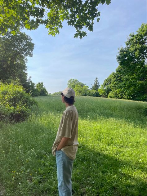 person standing in a field wearing light neutral colors and jeans Granola Boy Haircut, Outdoorsy Style Men Summer, Granola Aesthetic Men, Indie Boy Aesthetic, Granola Boy Aesthetic, Mountain Fits, Granola Guy Style, Granola Boy Outfits, Outdoorsy Style Men