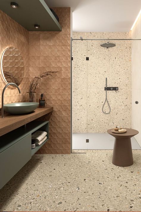 Rich in character and contrast, Arkistyle is a collection by Marca Corona that reinterprets Terrazzo tiles. Its Shade Warm variant flows beautifully both on the bathroom floor and the shower wall. Above the sink, Terracreta Forma Chamotte and its smooth embossment adorn the space with a soft caramel shade and complement the Multiforme Dune Tufo porcelain stoneware reflected on the mirror. Terrazzo Shower Wall, Terrazo Tiles Bathroom, Terrazzo Tiles Bathroom, Terazzo Floor, Bathroom Tiles Combination, Textures Murales, Bathroom Inspiration Modern, Unglazed Porcelain, Terrazzo Tiles