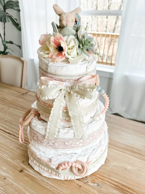 Spring / Easter themed baby girl diaper cake Diaper Tower Ideas, Creative Diaper Gifts, Diaper Cake Baby Girl, Cowgirl Diaper Cake, Floral Diaper Cake, Baby Girl Diaper Cake Ideas, Baby In Bloom Diaper Cake, Boho Diaper Cake Girl, Dipar Cake