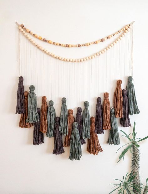 Yarn Tassel Garlands are a great way to incorporate texture and warmth into a space. Bring a bohemian flair to nurseries, living rooms, bedrooms, or party venues with a handmade Yarn Tassel Garland. Whether you're creating a cozy reading nook or sprucing up for a celebration, this garland is the perfect finishing touch. This item is made to order. Processing time is 1-3 days.  Measurements: Garland  Length: "34 laid flat, hung 30"  Depth - longest strung tassel is 33" Tassels Length: 10"  Like the garland but want a different color or length? I love custom orders! Hit the Custom Order button or send me a message of what you would like. Processing time for custom orders is 7 -10 business days. Shipping options: USPS Priority Mail (1-4 days) USPS First Class Mail (2-6 days) USPS Priority Mai Crochet Tassel Garland, Homemade Tassel Garland, Yarn Banner Diy Tassel Garland, Yarn Decorations, Yarn Garland, Yarn Tassel Garland, Diy Garlands, Diy Tassel Garland, Wall Decor Wedding