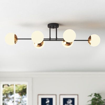 This 6-light semi-flush mount features a linear Sputnik design that brings plenty of mid-century modern style to your living area or dining room. The central fixture is made from metal in a sleek black tone with horizontal bars that face in all directions. At the end of each is a gold-finished holder that keeps in place a 20W max bulb (sold separately) and a white glass globe shade. We love that this mount is compatible with sloped ceilings, and it works with dimmer switches to move you effortle Kitchen Lighting Mid Century Modern, White Kitchen Lights, Mcm Track Lighting, Kitchen Lighting Fixtures Semi Flush, Flushmount Ceiling Lights Kitchen, Semi Flush Dining Room Lighting, Linear Flush Mount Lighting, Semi Flush Kitchen Lighting, Scandinavian Interior Lighting