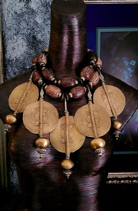 This stunning bespoke African tribal - ethnic oversized beaded chest piece is from my private vault and it is now available for purchase! Five oversized African lost wax brass Baule sun disks are featured in this piece. Each of these 3.5" jumbo size brass beads are currently retailing for $100.00 each!! A huge brass bicone is suspended from the end of each disk along with a brass rhinestone rondelle, various metal beads and a black seed bead. The necklace adjusts from 16-20" and closes with gold tone hardware, a fancy xl lobster claw clasp and a 4" extender chain. The necklace is comprised of huge wood beads, wood rondelles, brass spacers, African lost wax brass beads and ornate gold tone round beads. A lightweight and comfortable piece from the Atelier of Kat Kouture! Rocker Chic Accessories, Trill Art, African Inspired Decor, African Royalty, Unique Pendant Necklace, African Necklace, Brass Beads, Chest Piece, Advanced Style