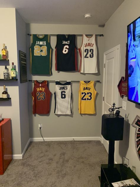 Framed Jerseys On Wall Bedroom, Jersey On Wall Ideas, Shelves For Sports Memorabilia, Jersey Storage Ideas, Jersey Decorating Ideas, How To Hang Jerseys On Wall, Jersey Room Decor, Athlete Room Ideas, Hang Jersey On Wall Ideas