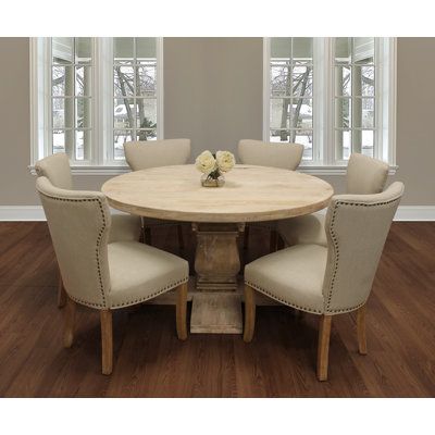 This 6-person dining set ties together traditional craftsmanship with an elegant modern twist. It includes one 58" round solid wood dining table, and 6 purple linen upholstered side chairs. This table is finished in a hand-distressed white wash to bring out the natural wood grain variation. Each chair features solid wood legs and nailhead trim for a touch of class. Chair Color: Cream/Beige | MOTI Furniture 6 - Person Mango Solid Wood Dining Set Wood / Upholstered Chairs in Brown / Indigo / White Round Table Dining Room, Cream Dining Room, White Dining Room Sets, Oval Dining Room Table, Kitchen Table And Chairs, Farmhouse Dining Set, Breakfast Nook Dining Set, Round Dining Room Sets, Round Table And Chairs