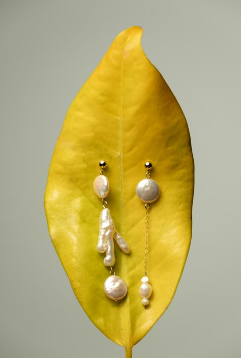 Discover the charm of individuality with our Mismatched Keshi Pearl Earrings, where no two pearls are alike. Celebrate your distinct style with these luminous Keshi pearls, each pair offering an exclusive dance of shapes and luster. One-of-a-kind: Every earring is uniquely formed, reflecting your personal flair.Radiant Luster: The all-nacre composition of Keshi pearls provides an unmatched sheen.Modern Asymmetry: Embrace a contemporary look with subtly varied pearls in each pair.Versatile Wear: Luxury Handmade Baroque Pearl Earrings, Mismatched Pearl Earrings, Pearl Jewelry Photoshoot, Modern White Pearl Chain Earrings, Modern White Pearl Earrings With Pearl Chain, Jewellery Ads Creative, Earring Photography Ideas, Earring Product Photography, Earrings Photography Ideas