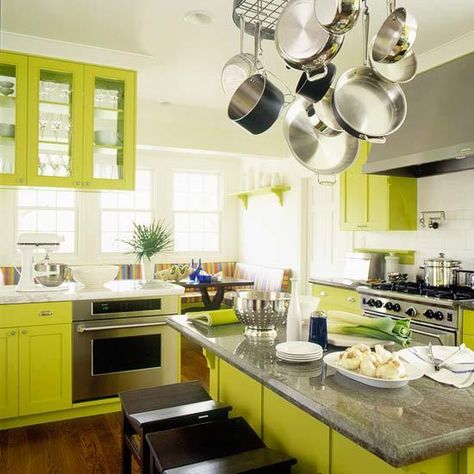 Vibrant chartreuse cabinets make a dramatic statement in a kitchen that begins with sterile white walls. Stainless-steel appliances and glossy gray granite countertops add polish, while a striped banquette in the corner injects tropical flair. The room is grounded with richly stained hardwood planks. Japandi Kitchen Design, Lime Green Kitchen, Green Kitchen Designs, Kitchen Design Color, Green Kitchen Cabinets, Fresh Kitchen, Minimalist Kitchen Design, Green Cabinets, Kitchen Design Trends