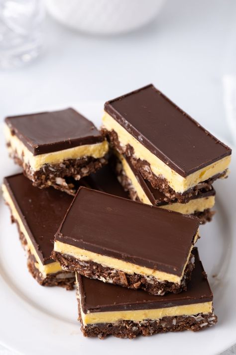 From the coconutty base to the creamy custard filling and silky chocolate ganache on top, Nanaimo bars are about as dreamy as Canadian desserts get. Canadian Desserts, Nanaimo Bars Recipe, Nanaimo Bar Recipe, Canadian Dessert, Nanaimo Bars, Cream Custard, Canada Food, Canadian Food, Custard Filling