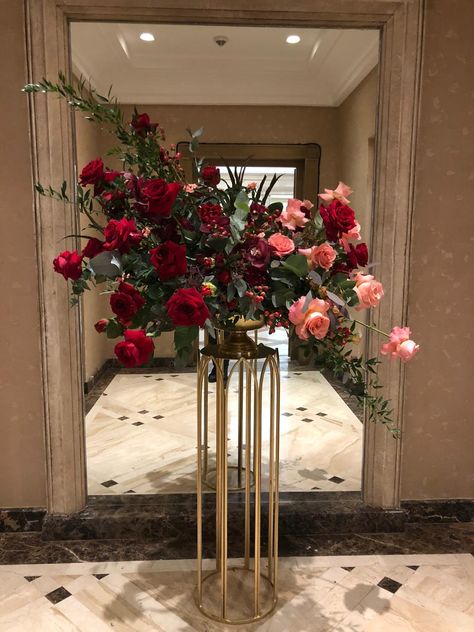 Floral Podium Arrangement, Red And Green Centerpieces, Red And Gold Floral Arrangements, Tall Floral Arrangements, Red Centerpieces, Dozen Red Roses, Flower Backdrop Wedding, Green Centerpieces, Large Flower Arrangements