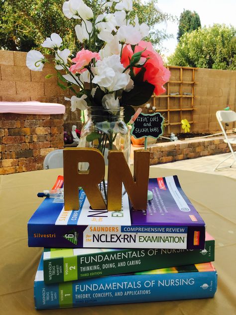 Nursing graduation centerpiece idea! Books and flowers #nursingschool #RN #nursegraduation Rose Gold Nursing Graduation Party, Nursing Centerpieces Graduation, Nurse Party Centerpieces, Nurse Graduation Party Ideas, Nursing Graduation Party Ideas, Dnp Graduation, Graduation Party Outfit, Grad Party Centerpieces, Nurse Grad Parties