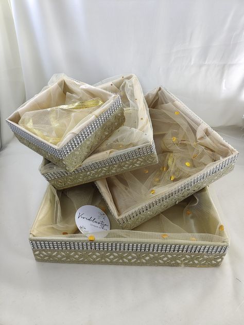 ENCHANT YOUR OCCASIONS WITH OUR SPECIAL WEDDING GIFT  SPECIAL SHAGUN TRAY  >< Product Contains ><  * Shagun Tray Set Of (4)  >< Product Details ><  * Product Name : Shagun tray * Material : Fabric, MDF, Net, Laces * Extra small : (L*W*H) - 6 x 6 x 2.5 Inches Approx * Small Size : (L*W*H) - 8 x 8 x 2.5 Inches Approx * Medium Size : (L*W*H) - 10 x 10 x 2.5 Inches Approx * Large Size : (L*W*H) - 12 x 12 x 2.5 Inches Approx  >< Product Usage ><  * The Shagun tray is an ideal choice for engagement ce Nikkah Gift Basket, Roka Shagun Basket, Engagement Gift Baskets Indian, Shagun Basket, Dry Fruit Basket, Engagement Gift Baskets, Baby Shower Hamper, Indian Wedding Gifts, Hamper Gift Basket