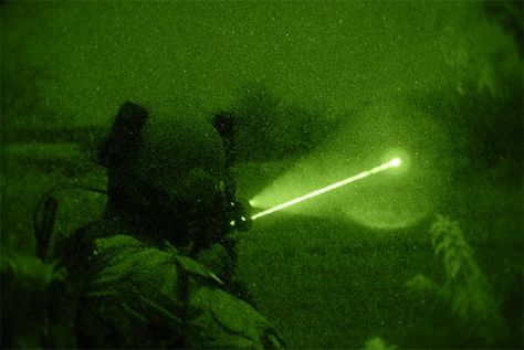 An American Special Forces soldier uses an infrared laser pointer and illuminator device mounted on his rifle to scan for enemy activity during a night op in Afghanistan.  Devices such as the PEQ-15 emit an infrared or visible search light and/or aiming device.  When wearing Night Vision Goggles (NVGs), the user can use the infrared modes to search and area / point at a target without giving away their position to non-nvg-equipped enemy. Beret Aesthetic, American Special Forces, Ghost Soldiers, Combat Arms, Night Vision Goggles, Military Aesthetic, Between Two Worlds, Green Beret, Special Operations