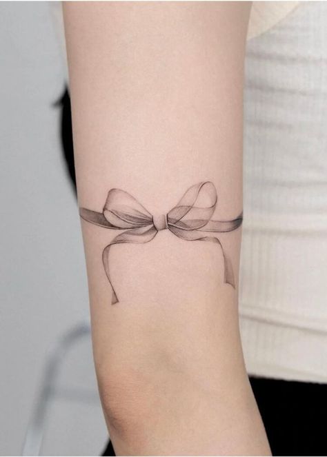 Explore bow tattoo meaning. Discover the symbolic meaning behind bow tattoos and get inspired with our collection of unique bow tattoo designs and bow tattoo ideas. Bow Tattoo On Stomach, Ribbon Bracelet Tattoo, Ribbon Arm Tattoo, Bow Bracelet Tattoo, Ribbon With Flowers Tattoo, Vintage Bow Tattoo, Thigh Ribbon Tattoo, Bow Tattoo Lower Back, Bow Tattoo Back Of Arm