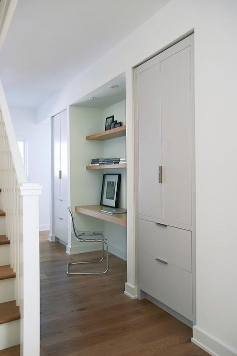 Foyer hall alcove is filled with a wood floating desk under stacked wood floating shelves paired with an Ikea Ghost Chair, Ikea Tobias Chair, flanked by alcoves filled with gray cabinets. Alcove In Living Room, Hallway Desk Ideas, Kitchen Alcove Ideas, Grey And White Hallway Ideas, Desk Alcove, Hallway Alcove, Grey And White Hallway, White Hallway Ideas, Hallway Desk