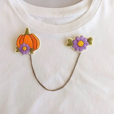 Embroidered Pumpkin Brooches with chain🍂 A unique, handmade piece inspired by nature. This chain necklace brooch features intricately embroidered pumpkin and flower motifs.👌🏻 Connected by a delicate 20 cm chain, these two brooches will add elegance to any outfit. Each brooch is carefully handcrafted, adding a distinctive touch to your outfits.🪡 ⭐ Available in StarryNeedleWork Etsy shop ✈️ Worldwide Shipping ⭐ ETSY shop link is in my bio #fallaccessories #pumpkinbrooch #embroideredbro... Pumpkin Brooch, Embroidered Pumpkin, Embroidered Brooch, Flower Motifs, Halloween Embroidery, Pumpkin Fall, Fall Accessories, Accessories Handmade, Brooches Handmade