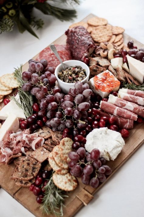 How to Create a Festive & Rustic Holiday Charcuterie Board - This step-by-step guide will help you create the perfect DIY rustic charcuterie board for your next party. Includes ideas on how to balance your board, how to garnish it, and what ingredients work best. This board uses a mixture of soft and hard cheeses, cured meats, jams & jellies, grapes, mixed nuts, crackers, and olive topenade from Trader Joe's. Ideas for garnish include fresh rosemary sprigs. - Rain and Pine Christmas Charcuterie Board Ideas, Holiday Charcuterie Board, Perfect Charcuterie Board, Holiday Charcuterie, Christmas Charcuterie Board, Chocolate Vodka, Christmas Pizza, Holiday Facts, Christmas Charcuterie