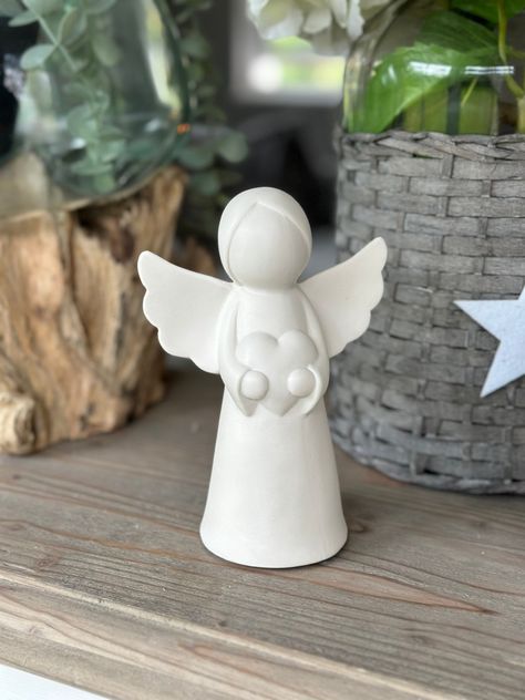 LED White ceramic glazed Angel holding a Heart. A delightful christmas ornament with LED lights, featuring a sweet angel, holding a heart. Complete with a matte white finish and a festive feel.  Two sizes available. Small - 10cm x 11.5cm Medium  - 12cm x 16cm (Batteries Included) Sending as a gift? Select Gift at checkout and add your personal message. Gifts are sent without priced invoices. Angel Ceramic Handmade, Angel Clay Sculpture, Ceramic Angel Ornament, Pottery Angels Christmas, Ceramic Christmas Decor, Pottery Angels Hand Built, White Clay Ideas, Christmas Ceramic Ornaments, Clay Angels Handmade