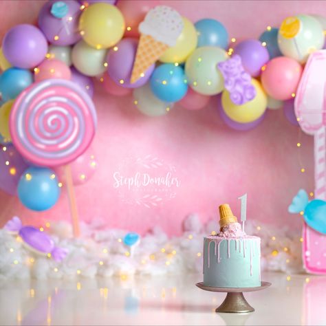 Candyland themed cake smash set. The backdrop is pink, and there's a bright balloon garland with purple, pink, blue and yellow balloons. Lots of candy scattered around the set, and an ice cream themed cake! Birthday Theme For Photoshoot, Candy Land Theme Photoshoot, Candyland Birthday Photoshoot, Two Sweet Party 2nd Birthday Photoshoot, Candyland Theme Photoshoot, Candyland Smash Cake, Sweet One Photoshoot Baby, 2nd Year Birthday Ideas Girl, Candyland Photoshoot Ideas