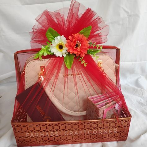 A metal basket with handbag, wrapped with red net cloth. Gift Wrapping With Net Cloth, Handbag Gift Wrapping Ideas, Gift Hamper Wrapping Ideas, Hamper Wrapping Ideas, Hamper Decoration Ideas Gift, Clothes Hamper Ideas, Hamper Diy, Rakhi Hampers, Handmade Hamper