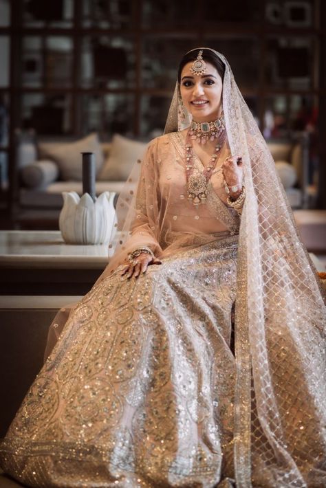 Bride in a powder pink lehenga. A pale shade of pink that is in the pastel family has been a bridal favourite off late for your wedding day. It’s perfect for a day wedding as well as an evening soiree, light enough to not overpower you as well as unique enough to style. Looks like the colour powder pink is going to be a chosen one of 2021 weddings! Sabyasachi Bridal Lehenga Collection Pink, Subtle Bridal Lehenga, Pastel Bride Lehenga, Light Colour Lehenga For Bride, Pastel Bride Indian, Light Bridal Lehenga, Light Pink Wedding Lehenga, Pastel Reception Lehenga, Indian Bride Pastel Bridal Lehenga