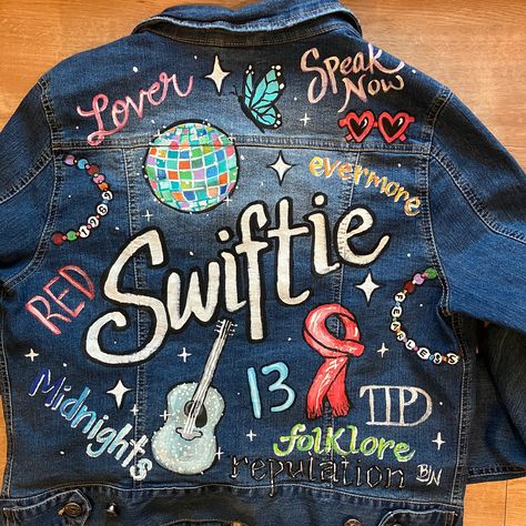 Painted Jackets I’ve made this summer… 📣 Derrick Dolls Cheerleader - reunion 🤠 George Strait - concert/festival 🕶️ Taylor Swift - teenager’s bday gift 🎶 Nashville - going away/moving gift 🦋 T Swift Collage - teenager’s bday gift 🇺🇸 Toby Keith - super fan gift 🏀 Anthony Edwards - to sell in my shop 💍 Mrs. “Bride” - to promote in my shop 🎸 Rolling Stones - concert fashion 🪩 Taylor Swift - concert & 50th bday look Which one is your favorite? Etsy Artist | Custom Painted Denim Jack... Birthday Gift For Taylor Swift Fan, The Eras Tour Jean Jacket, Eras Jacket Diy, Swiftie Jean Jacket, Taylor Swift Custom Jacket, Eras Denim Jacket, Eras Tour Denim Jacket Diy, Eras Tour Jean Jacket Diy, Eras Jean Jacket