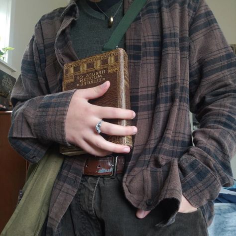 an outfit consisting of a brown checkered shirt over green sweater tucked into brown pants. the person is wearing this outfit and holding an old book. Mens Fall Outfits Dark Academia, Fall Mens Aesthetic, Cryptidcore Academia, Dark Academia Gender Neutral, Goblincore Men Outfits, Chaotic Academia Outfits Masc, Goblincore Dark Academia, Hobbitcore Fashion Men, Forest Academia Aesthetic