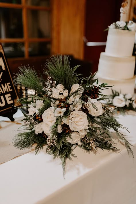 Pinecones, white roses, evergreen, pine bouquet Winter Wedding Bouquet Evergreen White Roses, Winter White Rose Bouquet, Pine Winter Wedding Centerpieces, Winter Wedding Floral Decor, White Christmas Bouquet, Evergreen Bridal Bouquet, Evergreen Wedding Centerpiece, Pine Centerpiece Wedding, Pine Wedding Bouquet