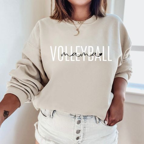 "The minimalist \"Volleyball Mama Sweatshirt\" is a sturdy and warm crewneck sweatshirt bound to keep you warm in the colder months. These cozy sweatshirts make a great gift for baseball lovers! A pre-shrunk, classic fit sweater that's made with air-jet spun yarn for a soft feel and reduced pilling. Sweatshirt details: * 50% cotton, 50% polyester * Pre-shrunk * Classic fit with no center crease * 1x1 athletic rib knit collar with spandex * Air-jet spun yarn with a soft feel and reduced pilling * Volleyball Sweatshirts, Custom Crewneck Sweatshirts, Baseball Sweatshirts, Volleyball Mom, Gildan Sweatshirt, Nurse Sweatshirt, Mama T Shirt, Softball Mom, Mama Sweatshirt