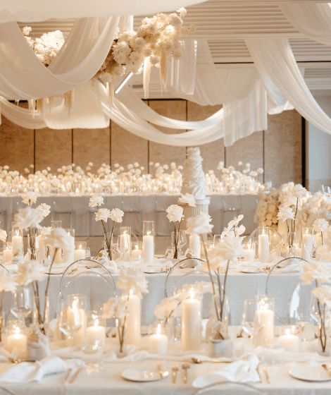 Here’s How To Pull Off a Luxurious All-White Wedding Theme White Cream Ivory Wedding, Off White Wedding Decorations, Minimal Center Piece Wedding, White Neutral Wedding Decor, White And Glass Wedding Decor, Ivory Party Decorations, Rose Gold White Wedding Decor, White And Candle Wedding, Ivory Decor Wedding