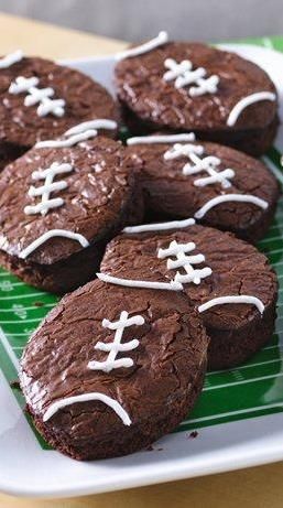 You’re sure to score many points with the football fans in your life once these football-shaped brownies hit the snack table. This creative game-day dessert is as easy as making boxed brownies—all you need is a football-shaped cutter (or a knife if you want to freestyle it) and some icing for the “laces.” Football Brownies, Football Treats, Football Cookies, Football Snacks, Football Party Food, Brownie Desserts, Superbowl Snacks, Super Bowl Party, Superbowl Party Food