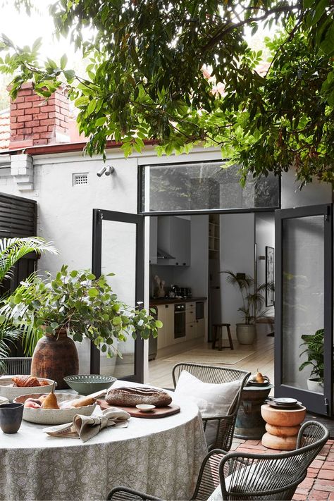 A courtyard with a table styled ready for a meal. Two doors open out from the open-plan dining room inside. A tall tree creates shade overhead. Patio Budget, Victorian Terrace Renovation, Courtyard Patio, Patio Areas, Small Outdoor Patios, Courtyard Design, Outdoor Dining Spaces, Fresh Color Palette, Melbourne House