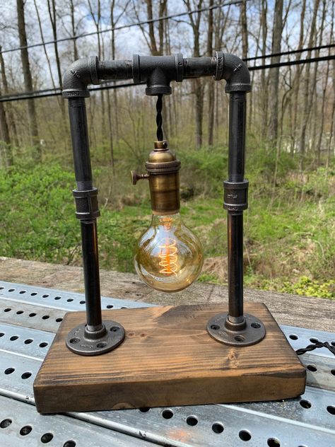 "Industrial style lamp, perfectly bold desk decor and accent lighting for any home or office space. Wooden base measure roughly 11\"x6\"x2\" while the overall height of the fixture stands 13\". With a Polished brass socket and black twisted cloth wire, the lamp plugs directly into any standard outlet.  *Lightly burned and sealed bases now available, request either stained or burned!* *edison bulb not included, sorry for any inconvenience*" Lamp Plugs, Electrical Ideas, Industrial Lamp Design, Pipe Lights, Lampe Steampunk, Lamp Pipes, Industrial Pipe Lamp, Industrial Style Lamps, Industrial Diy