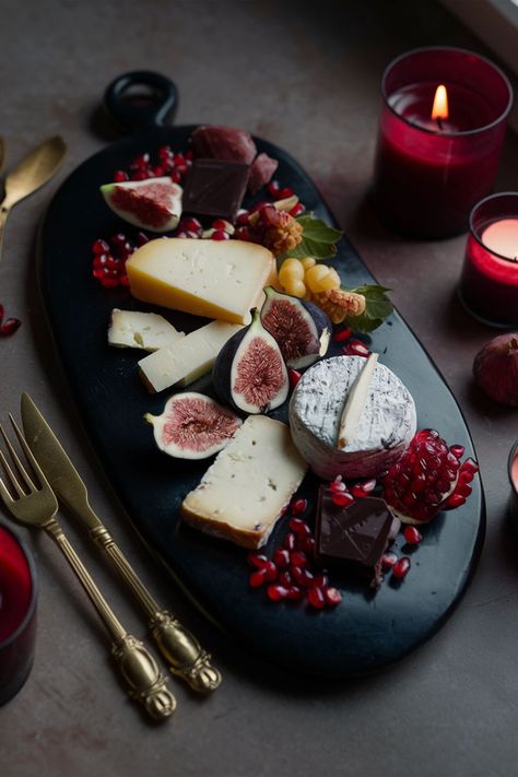 A sleek, black ceramic cheese board with a variety of cheeses, figs, pomegranate seeds, and dark chocolate, surrounded by antique gold cutlery and deep red candles. Soft, moody lighting. Cheese Board Aesthetic, Ceramic Cheese Board, Board Aesthetic, Board Inspiration, Aesthetic Dark, Black Ceramic, A Black, Cheese Board, Cheese