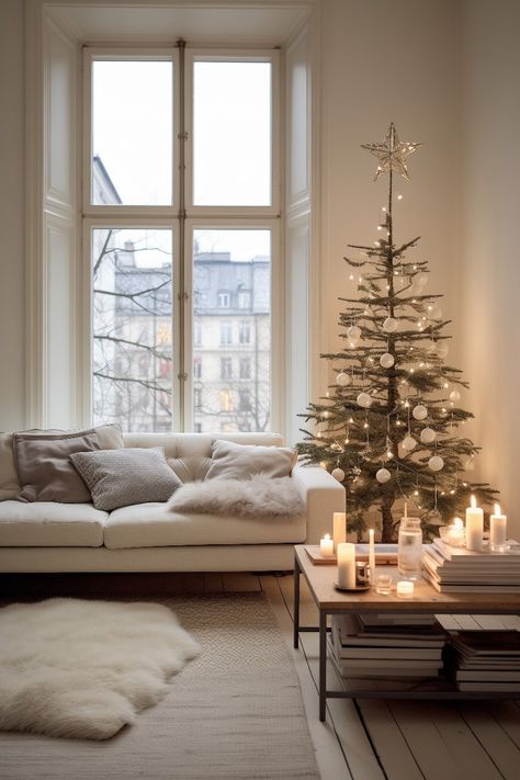 This minimalistic nordic holiday decoration fits a simple taste. The early 1900s apartment with large windows and wooden floors create a perfect setting for the white sofa with big pillows, white rug and fur on the floor, wooden coffee table with black metal frame, candles and medium sized christmas tree with elegant white decorations and lights. Simple Scandinavian Christmas, 1900s Apartment, Christmas Tree Scandinavian Style, Apartment With Large Windows, Ginger Cakes, Nordic Christmas Tree, Pillows White, Glam Christmas, White Sofa