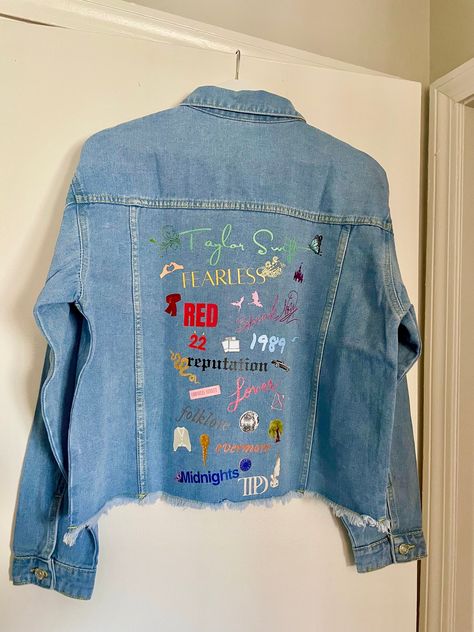 Stay in style with this classic medium wash denim jacket, customized to celebrate all of Taylor's iconic eras. Featuring images representing each album and various songs. Women's Jean Jacket Frayed Washed Button Up Cropped Denim Jacket With Pockets 65% Cotton, 35% Polyester Stylish raw hem, two chest fake pockets, two side slant hand pockets, turndown collar, button cuffs Design is DTF heat transfer decal, hand pressed.  Variations and small imperfections may occur as it is a handmade product, each design pressed individually. Taylor Swift Eras Denim Jacket, Taylor Swift Eras Jean Jacket, Swiftie Jean Jacket, Lover Jean Jacket Taylor Swift, Eras Tour Jean Jacket Diy, Taylor Swift Painted Jacket, Taylor Swift Jacket Diy, Taylor Swift Jean Jacket Diy, Eras Tour Jean Jacket