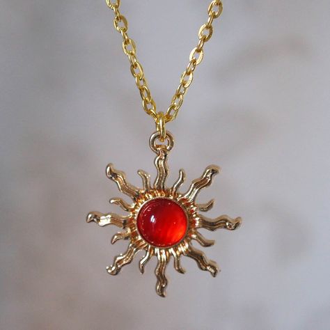 Make a statement with this pretty red sun necklace for women. This cool quirky gold plated and acrylic red sun necklace is a great way to add a nice touch to your outfit. The charm on this ladies sun necklace measures at 3cm x 2.7cm and is attached to a gold plated chain with lobster clasp. Various lengths of necklace chain are available, please select a length from the drop down menu. Please feel free to get in touch with us at Funky Earrings UK if you have any questions. We also have a wide ra Sun Clothes Aesthetic, Gold Red Necklace, Cool Gold Jewelry, Gold And Red Aesthetic, Red Jewelry Aesthetic, Red Aesthetic Fashion, Red And Gold Aesthetic, Red Gold Jewelry, Sun Accessories