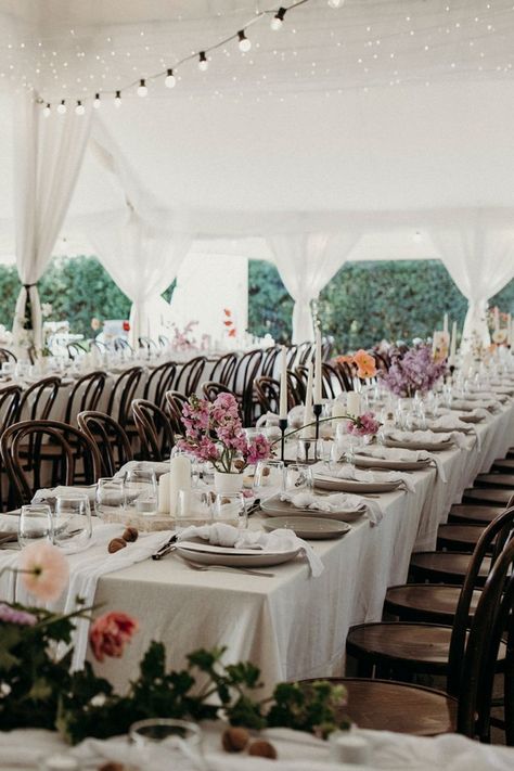 styling of a white wedding reception tent with long table rows, brown bentwood chairs, oatmeal tablecloths, white napkins, taper and pillar candles, menus, cutlery and floral arrangements Brown Chairs Wedding, Black Taper Candle Holders, Styling Candles, Spring Wedding Reception, Floral Centrepieces, Chairs Wedding, Romantic Spring Wedding, Black Taper Candles, Silver Cutlery