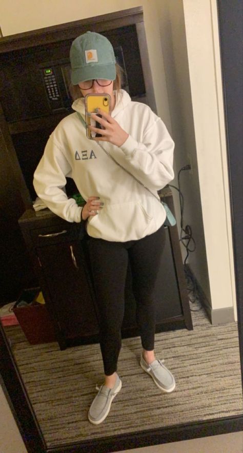 Sorority hoodie with black leggings and grey hey dude shoes topped with a sage green carrhart baseball cap Hey Dudes And Leggings, Outfits With Hey Dudes For Women Casual, Dresses With Hey Dudes, Fuzzy Hey Dudes Outfit, Black Hey Dudes Outfit Women, Cute Outfits With Hey Dudes, Black Hey Dudes Outfit, Hey Dude Outfits For Women, Cute Outfits With Hey Dude Shoes