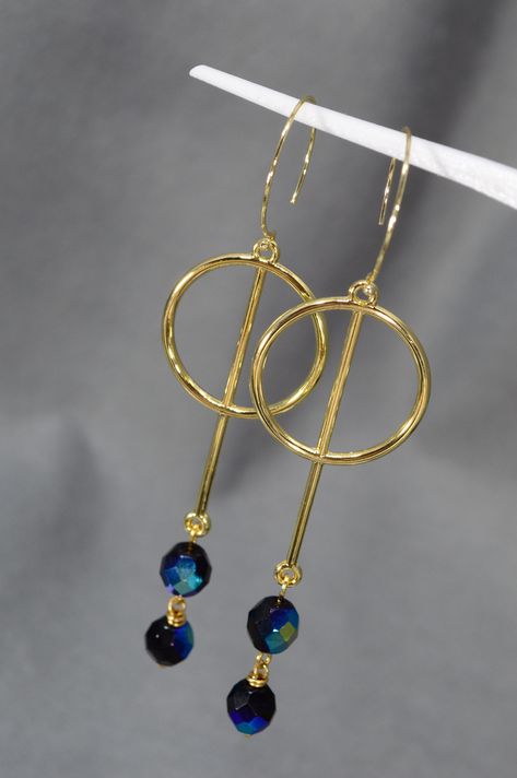 These earrings from Estibela Design are an elegant blend of style and sparkle, crafted with golden steel hooks and alloy zinc pendants. The black Czech glass beads with shiny blue edges create an incredible shimmering effect under any lighting. These earrings are perfect for various outfits and occasions, making them a versatile and essential accessory for every woman. The stunning design of these earrings immediately catches the eye, adding sophistication and refinement to your look. Whether yo Diy Gold Earrings, Handmade Earrings Ideas, Glass Bead Crafts Diy, Glass Bead Crafts, Wire Jewelry Earrings, Earrings Beads, Earring Kit, Aluminum Jewelry, Earrings Golden