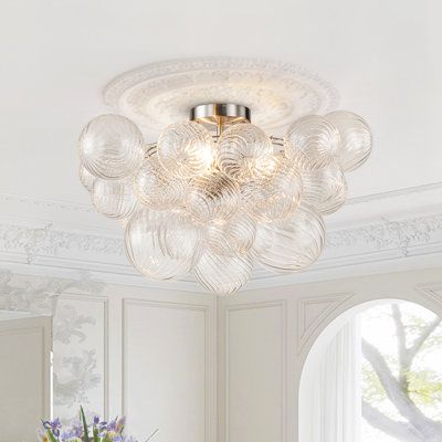 Add some sparkle and style to your ceiling with this 3-light ribbed glass bubble semi-flush mount. It features multiple clear ribbed glass shades that resemble bubbles floating in the air. The brass-finished metal frame adds a touch of elegance and contrast to the glass. The ribbed bubble semi-flush ceiling light is compatible with three E12 bulbs (not included). Light filters through the ribbed glass shade, refracting beautiful patterns on the ceiling. It is perfect for adding some glamour and Modern Flush Mount Ceiling Light, Wall String Lights, Floating In The Air, Light Filters, Glass Bubble, Bubble Lights, Semi Flush Ceiling Lights, Light Fixtures Flush Mount, Ribbed Glass