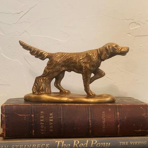 This unique antiqued brass pointer dog can be used as a paperweight or as tabletop decor. Makes an elegant addition to office, hunting cabin or lodge, or a great gift for an hunting or outdoors enthusiast.- 3-1/2" tall, 6" long base- Heavy, solid antiqued brass for a vintage look- Beautiful etched detailing Vintage Decor Office, Vintage Cabin Decor Living Room, Vintage Hunting Bedroom, Vintage Hunting Art, English Hunting Lodge Decor, Hunting Lodge Bedroom, Vintage Hunting Nursery, Vintage Hunting Decor, Cabin House Decor