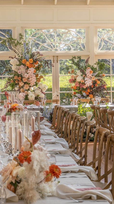 A reception room at the conservatory on location at Gabbinbar Homestead, styled with colourful florals with the tables set for guests with glasses, napkins, dinnerware in the soft afternoon light. Homestead Photography, 2025 Planning, Gabbinbar Homestead, Christian Creative, Poppy Wedding, Icelandic Poppies, Colourful Wedding, Fall Florals, Summer 2025