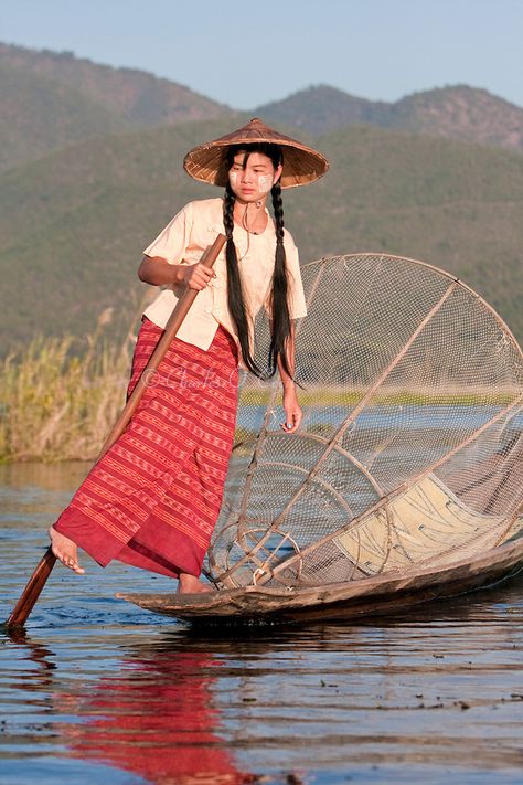 Myanmar, Burma. Young Burmese Woman Rowing with one Leg, Looking for a Place to Set her Fishing Net. Inle Lake, Shan State. She is wearing thanaka paste on her cheeks, a Burmese cosmetic sunscreen. Shan State, Women's Rowing, Myanmar Travel, Inle Lake, Burma Myanmar, Fishing Net, World Cultures, People Of The World, 인물 사진