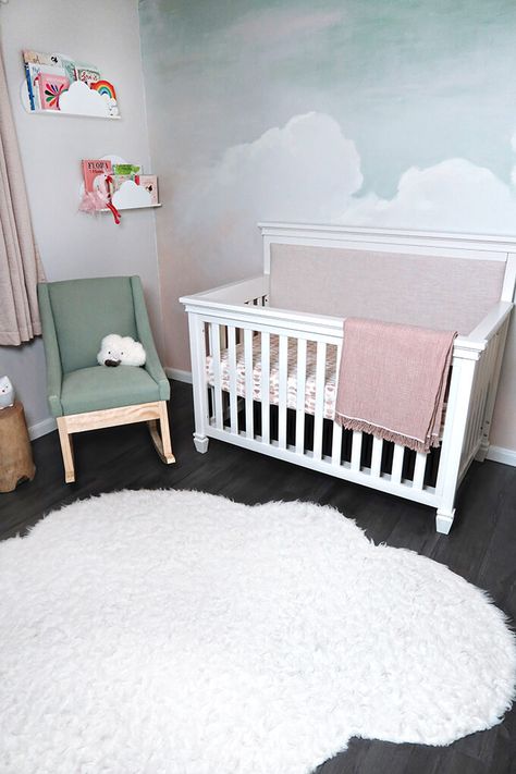 A gorgeous and calming cloud nursery. This sweet girl nursery has a beautiful hand painted sky mural and sweet bird art. #cloudnursery #girlnursery #MDBCstyle #girlnurseryinspo #nurseryinsipration #pinknursery #DarlingtonCrib Sky Mural Wall, Diy Cloud Mural, Cloud Mural Nursery, Clouds Nursery Theme, How To Paint Clouds On A Wall, Nursery Sky Theme, Baby Girl Nursery Mural, Sky Nursery Theme, Cloud Nursery Girl