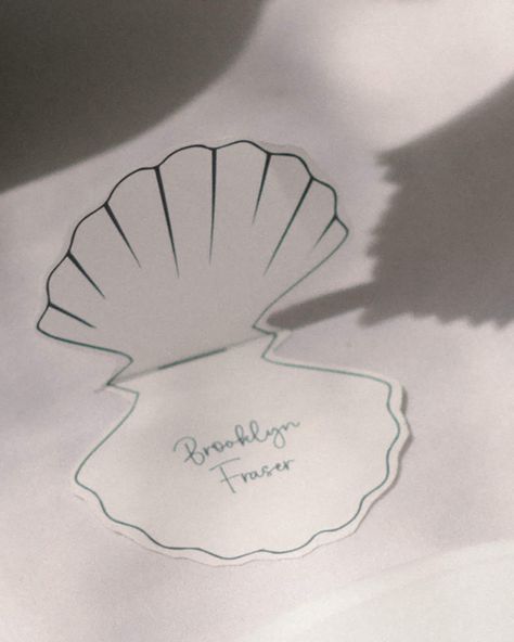 This elevated Shell Shaped Place Card is perfect for your next wedding, bridal shower, baby shower or event.  You can instantly download the editable template and begin placing your names. INSTANTLY EDIT WITH CANVA After your purchase, you will receive a link with a PDF file to your Shell Place Card Template within minutes of ordering. Open your email, click the link and upload your PDF file to Canva. You can edit the template immediately in your browser using Canva. We recommend duplicating each page and replacing the name content to ensure the size and shape stay consistent prior to printing. Upon the centre line, this is where you fold the place card to sit on the table like in the image above.  DOWNLOAD INCLUDES 15cm x 15cm Art board  Shell Design  Name text YOU CAN EDIT - Text - Font Seashell Place Cards Wedding, Shell Wedding Invitations, Place Cards Ideas, Name Cards For Wedding, Shell Place Cards, Coastal Chic Wedding, Unique Place Cards, Wedding Name Place Cards, Name Place Cards Wedding