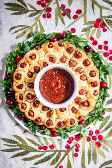 How to Make a Tear-Apart Pigs in a Blanket Wreath | eHow Mini Pigs In A Blanket Wreath, Mini Hot Dog Wreath, Appertiser Ideas For Christmas, Pull Apart Pigs In A Blanket Pioneer Woman, Wreath Food Christmas, Christmas Appetizers Easy For Kids, Christmas Apatizer Ideas, Mini Sausage Wreath, Little Smokies Wreath Christmas