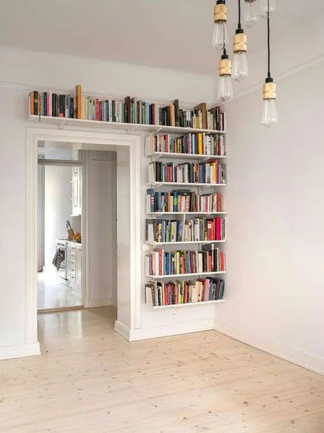 bookshelves covering one wall next to the doorway and a space over it will give you much space for books and will help you declutter the space Built In Over Doorway, Doorway Bookshelf, Inside House, Wall Storage, Home Library, Over It, The Space, Storage Solutions, Bookshelves